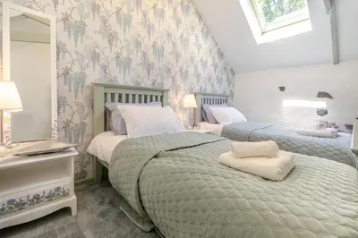 a bedroom with two beds and a mirror at 2 Bed in Trewoon oc-t29504 in St Austell