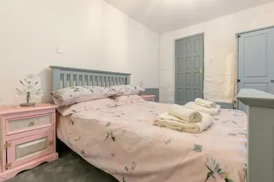 a bedroom with a pink bed with towels on it at 1 Bed in Trewoon oc-t29505 in St Austell