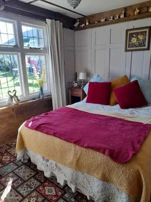 a bedroom with a large bed with red pillows at Puddle Duck Peeps Out Chalet in Saint Martin