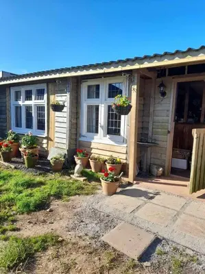 a house with potted plants in front of it at Puddle Duck Peeps Out Chalet in Saint Martin