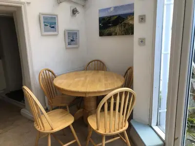 a wooden table and chairs in a room at 17th Century Traditional Tintagel Farmhouse with Hot Tub in Treknow