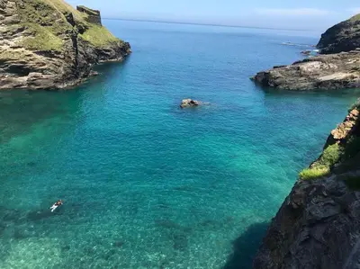 an aerial view of a body of water with rocks at 17th Century Traditional Tintagel Farmhouse with Hot Tub in Treknow