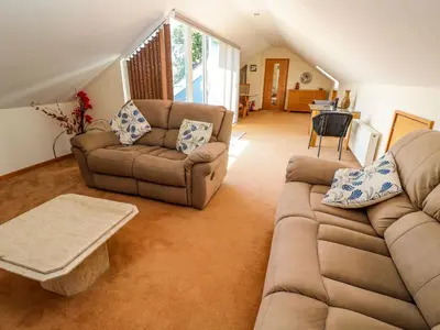 a living room with two couches and a table at The Crows Nest in Falmouth