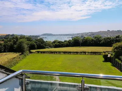 a view from the balcony of a house with a green field at The Crows Nest in Falmouth