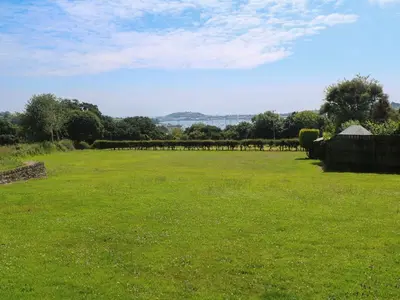 a large field of green grass with a fence at The Crows Nest in Falmouth