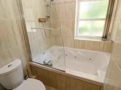 a bathroom with a tub and a toilet and a shower at The Crows Nest in Falmouth