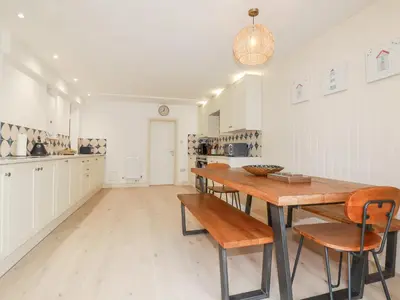 a kitchen with a wooden table and chairs at Serendib Cottage in Newquay