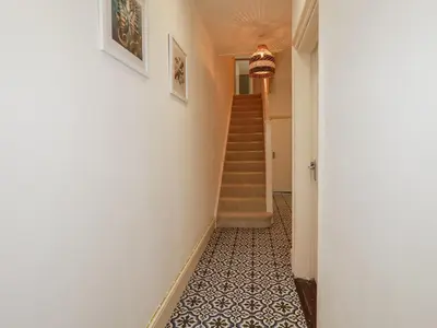 a hallway with a staircase with a tile floor at Serendib Cottage in Newquay