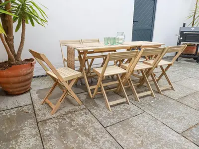 a wooden table and chairs on a patio at Serendib Cottage in Newquay