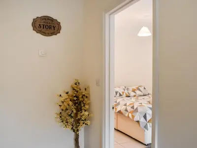 a bedroom with a bed and a clock on the wall at Lavrean Farm in St Austell