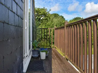 a balcony with potted plants on a house at Lavrean Farm in St Austell