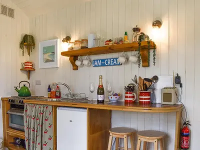 a kitchen with a counter with stools and a counter top at The Shepherds Hut At Rosewood House in Liskeard