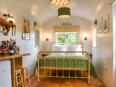a bedroom with a bed in a small room at The Shepherds Hut At Rosewood House in Liskeard