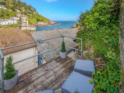 a wooden stairs with a view of the ocean at Charlie Wilcox Cottage in Polperro