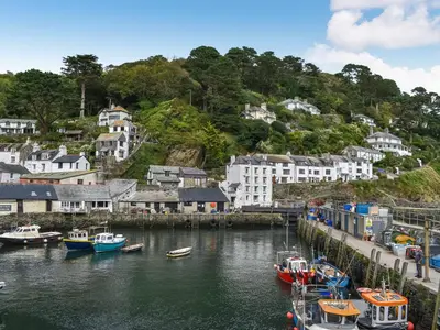 a group of boats are docked in a harbor at Charlie Wilcox Cottage in Polperro