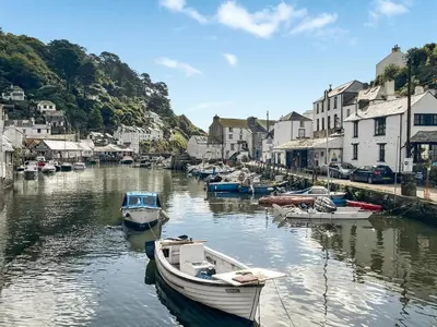 a group of boats docked in a river with houses at Charlie Wilcox Cottage in Polperro