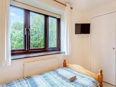 a bedroom with a bed and a window at River View in Wadebridge
