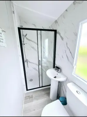 a bathroom with a shower and a toilet and a sink at Sandydaze in St Merryn