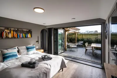 a bedroom with a bed and a sliding glass door at Uno Carbis Bay - Boutique Luxury Accommodation in Carbis Bay