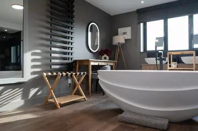 a bathroom with a large white tub and a mirror at Uno Carbis Bay - Boutique Luxury Accommodation in Carbis Bay