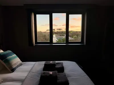 a bed in a dark room with a window at Uno Carbis Bay - Boutique Luxury Accommodation in Carbis Bay