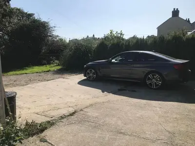 a car parked in the driveway of a house at Countryside Cabin in Private Setting in Redruth
