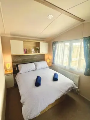 a bedroom with a bed with two blue shoes on it at The Lobster Pot in Tywardreath