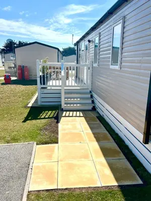 a porch with a white railing next to a house at The Lobster Pot in Tywardreath