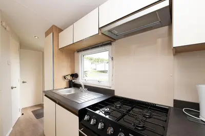 a kitchen with a stove and a sink at Tencreek Holiday Park in Looe
