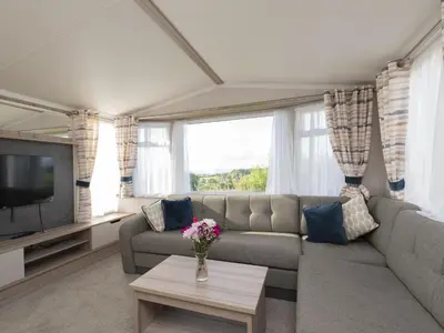 a living room with a couch and a tv at Tencreek Holiday Park in Looe