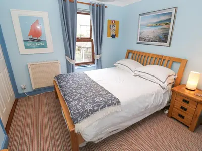 a bedroom with a large bed and a window at 5 Tregenna Court in Falmouth