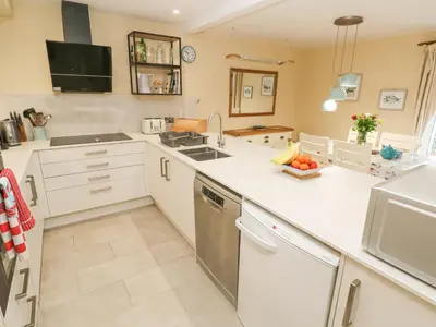 a kitchen with white cabinets and a counter top at 5 Tregenna Court in Falmouth