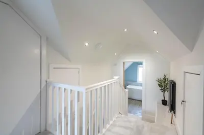 a white staircase in a white room with a tub at Griffin's Rest - Parking, Countryside views in Newquay