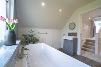 a bathroom with a large white tub and a sink at Griffin's Rest - Parking, Countryside views in Newquay