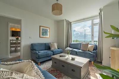 a living room with blue couches and a coffee table at Griffin's Rest - Parking, Countryside views in Newquay
