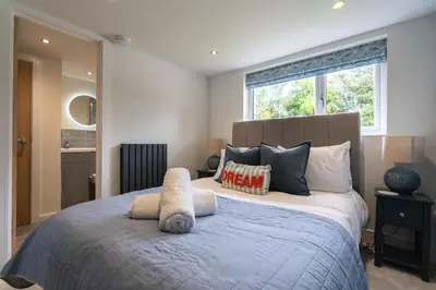 a bedroom with a large bed with pillows and a window at Griffin's Rest - Parking, Countryside views in Newquay