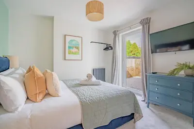 a bedroom with a bed with a blue dresser and a window at Griffin's Rest - Parking, Countryside views in Newquay