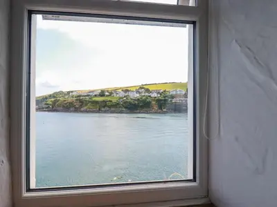 a window with a view of a body of water at Chy Rani in Portmellon