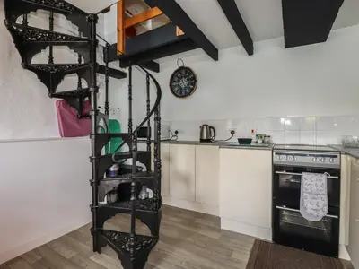 a kitchen with a black spiral shelf in a kitchen at Chy Rani in Portmellon