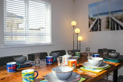 a wooden table with cups and plates on it at Chestnut House in Saint Columb Minor