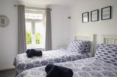 a bedroom with two beds and a window at Eventide in Newquay