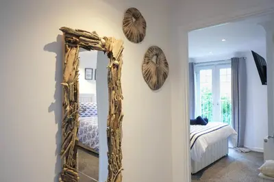 a mirror on a wall in a room with a bed at Eventide in Newquay