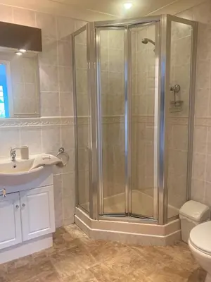 a bathroom with a shower and a toilet and a sink at Eventide in Newquay