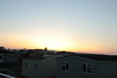 a sunset over a city with houses at Wee Cott in Hayle