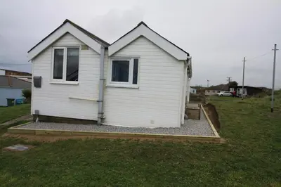 a white house with two windows in a yard at Wee Cott in Hayle