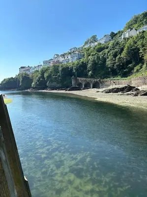 a body of water next to a beach with houses at Chy Pyscador in Looe