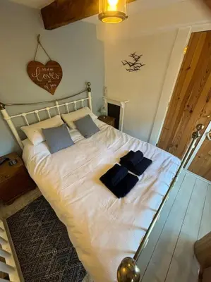a bedroom with a bed with blue pillows on it at Chy Pyscador in Looe