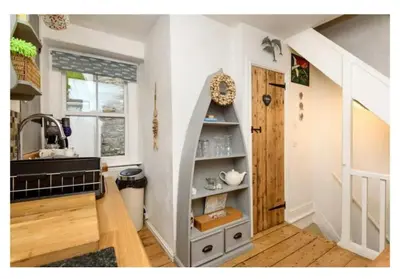 a room with a staircase with a book shelf at Chy Pyscador in Looe