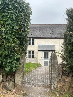 a gate in front of a house with an apple tree at 1 Carnebone Cottages in Porkellis
