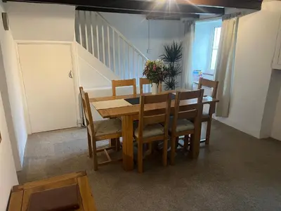 a dining room with a wooden table and chairs at 1 Carnebone Cottages in Porkellis